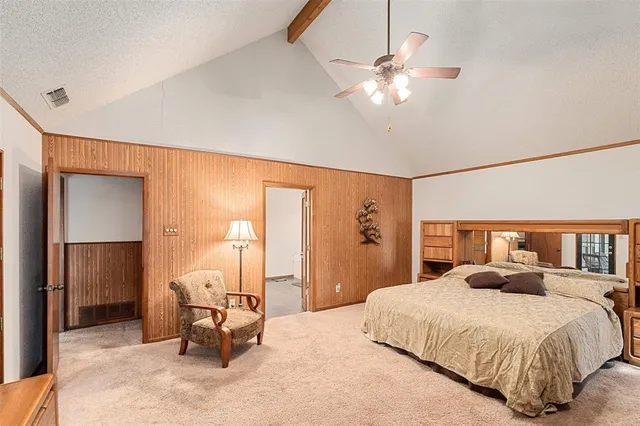 a bedroom with a large bed and a chandelier