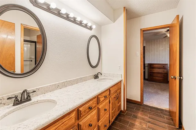 a bathroom with a granite countertop double vanity sink and a mirror