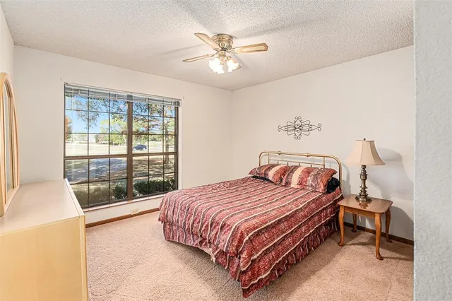 a bedroom with a bed and a large window with outer view