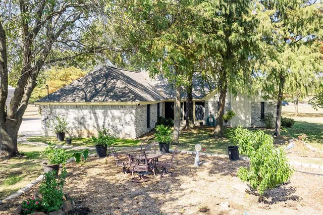 a backyard of a house with lots of green space and fountain