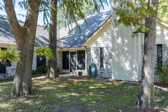 a view of a house with backyard and a tree