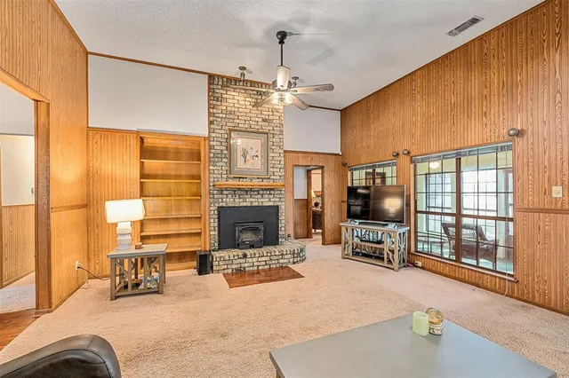 a living room with furniture a fireplace and chandelier