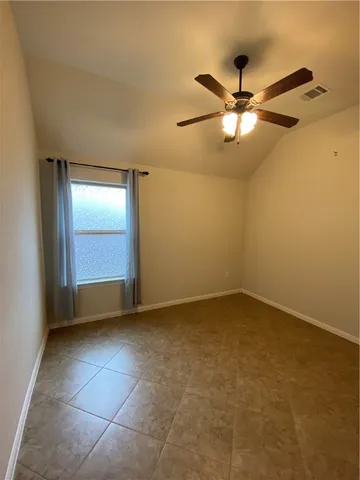 an empty room with a ceiling fan and a window