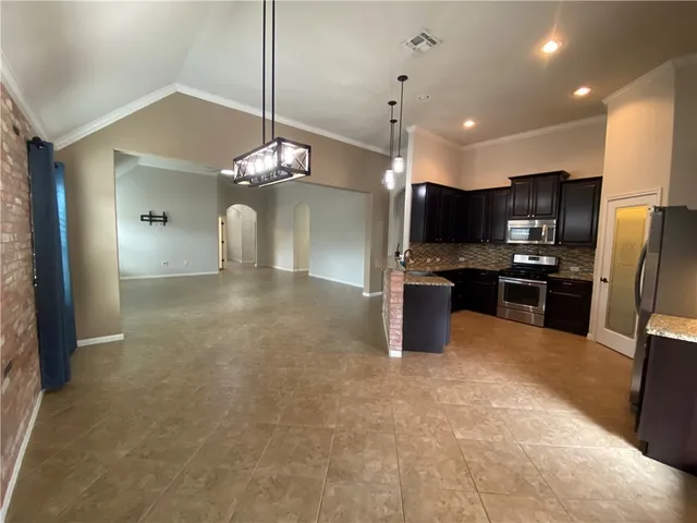 a view of a kitchen with stainless steel appliances a refrigerator and a microwave