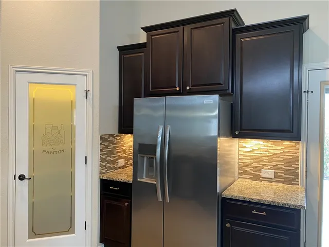 a kitchen with metallic refrigerator and window
