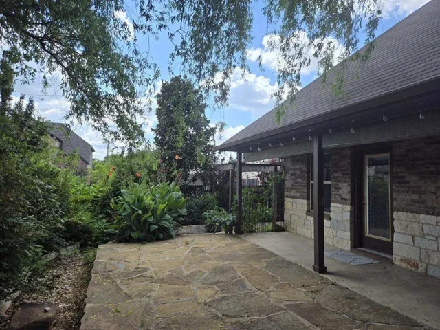 a view of a house with a yard and potted plants