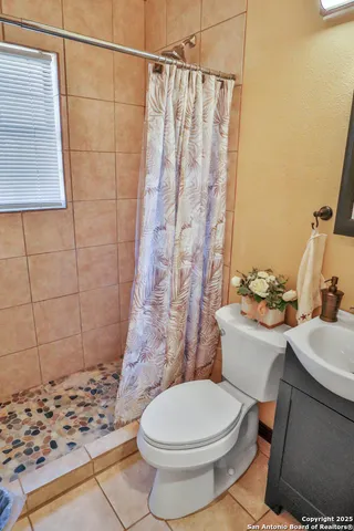 a white toilet sitting next to a shower curtain