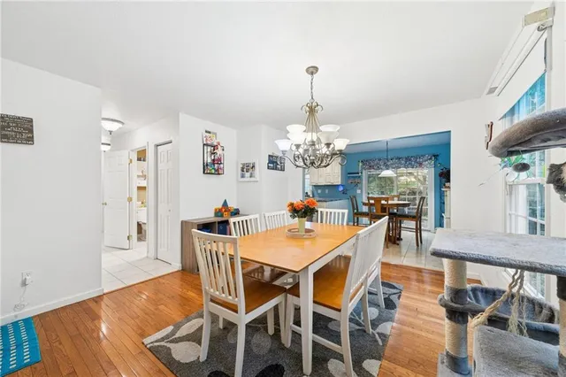 a view of a dining room with furniture a chandelier and wooden floor