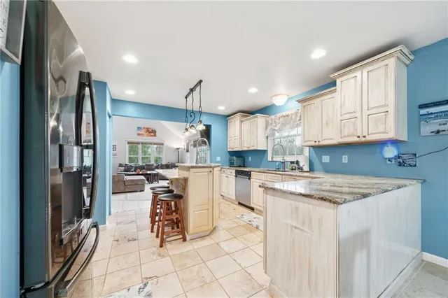 a kitchen with a sink a refrigerator and white cabinets