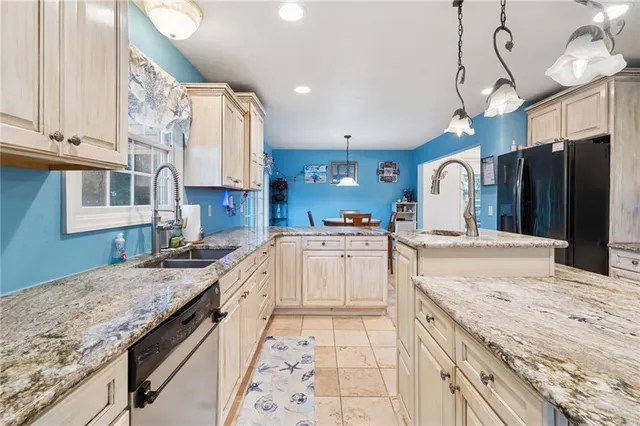 a large kitchen with stainless steel appliances granite countertop a sink and cabinets