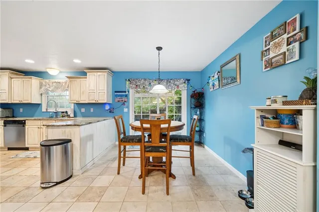 a dining room filled a chandelier and kitchen view