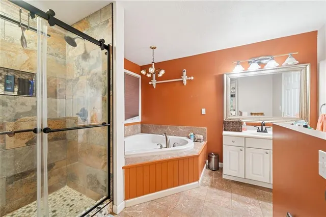 a bathroom with a tub sink shower and mirror