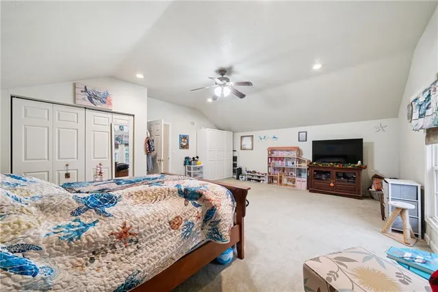 a spacious bedroom with a bed a couch and a flat screen tv