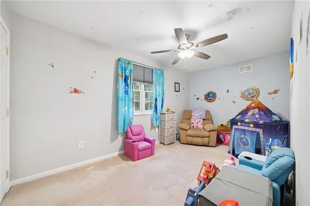 a bedroom with furniture and a chandelier fan
