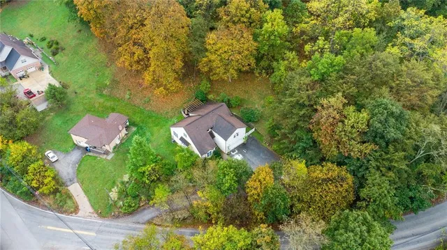 an aerial view of a house with garden space and street view