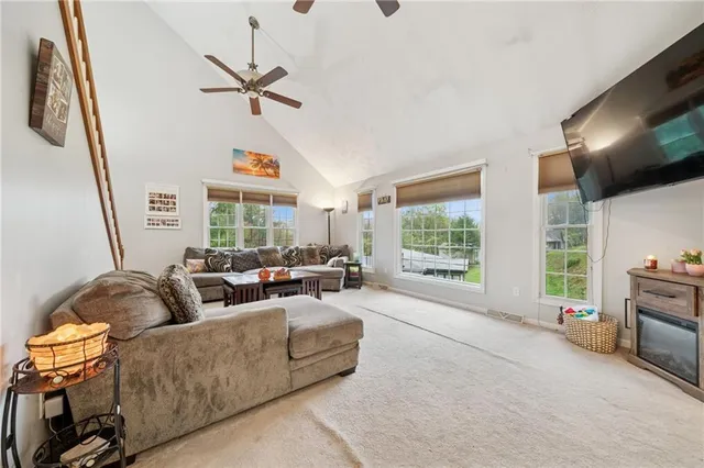a living room with furniture ceiling fan and a window