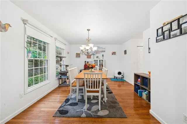 a dining room with wooden floor and a chandelier