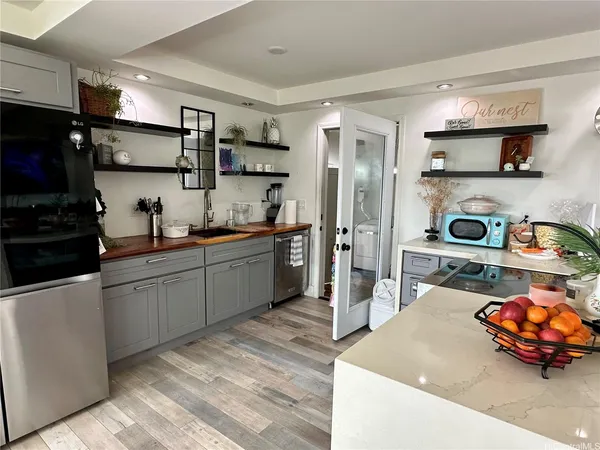 a kitchen with stainless steel appliances granite countertop a sink and a refrigerator