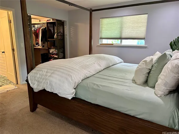 a bed sitting in a bedroom next to a window