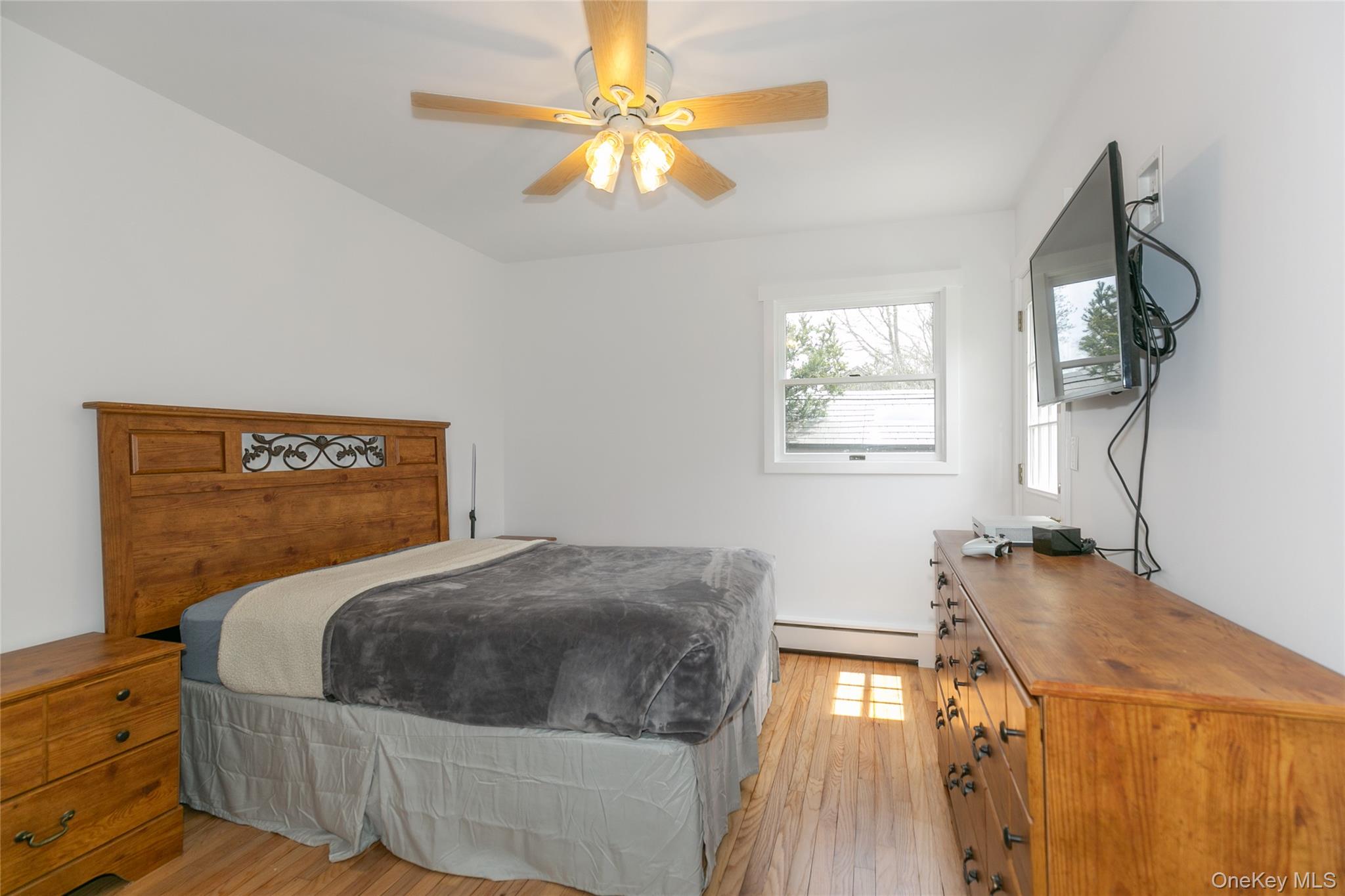 7 Suffolk Road Hampton Bays, NY 11946 - Photo 11 of 23 a bedroom with a bed and a chandelier