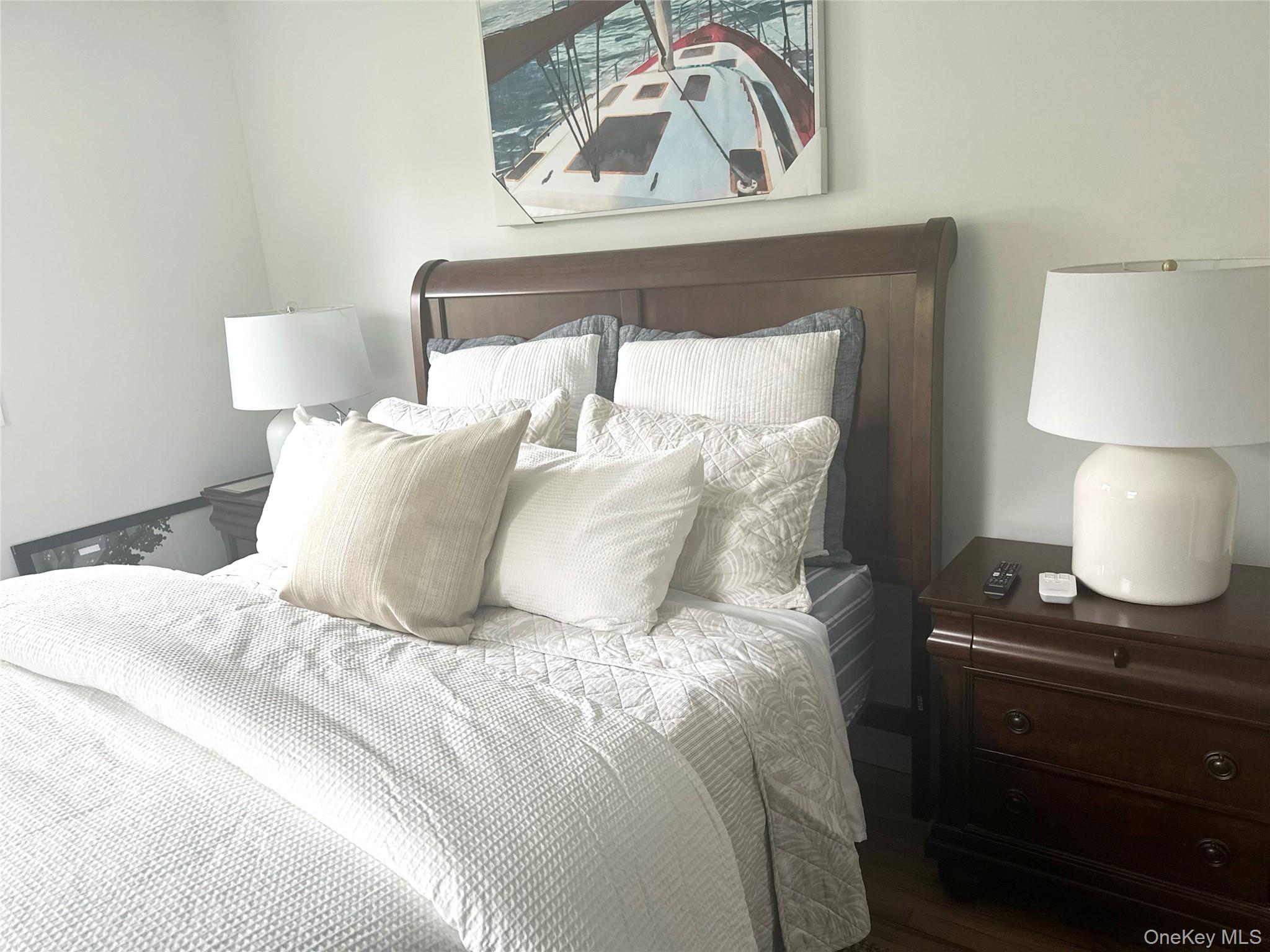 7 Suffolk Road Hampton Bays, NY 11946 - Photo 12 of 23 a large bed sitting in a bedroom next to a lamp