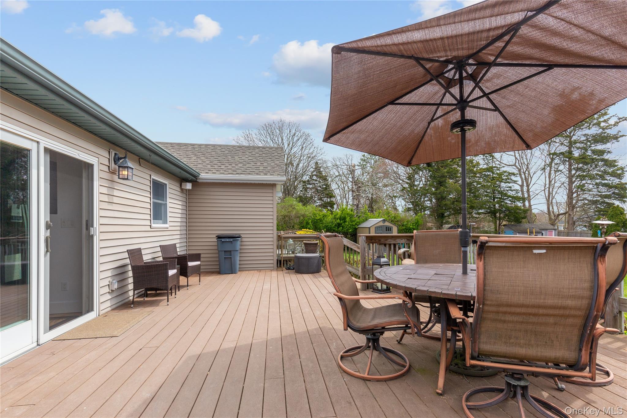 7 Suffolk Road Hampton Bays, NY 11946 - Photo 16 of 23 a view of a patio with table and chairs under an umbrella
