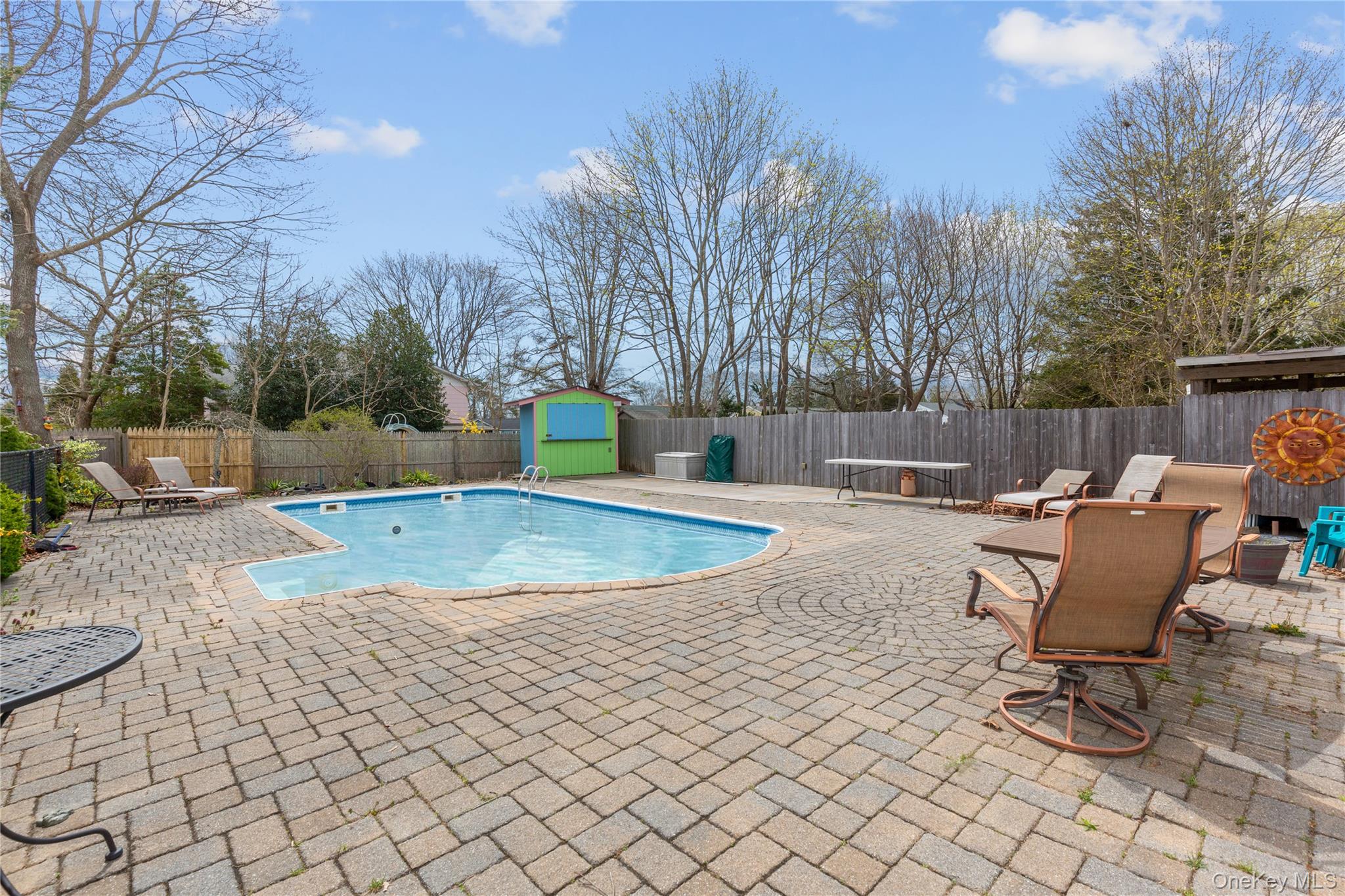 7 Suffolk Road Hampton Bays, NY 11946 - Photo 18 of 23 a view of a backyard with table and chairs