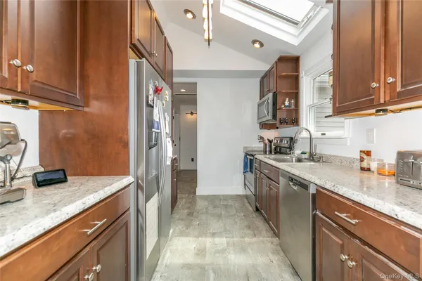 a kitchen with stainless steel appliances granite countertop a sink stove and refrigerator