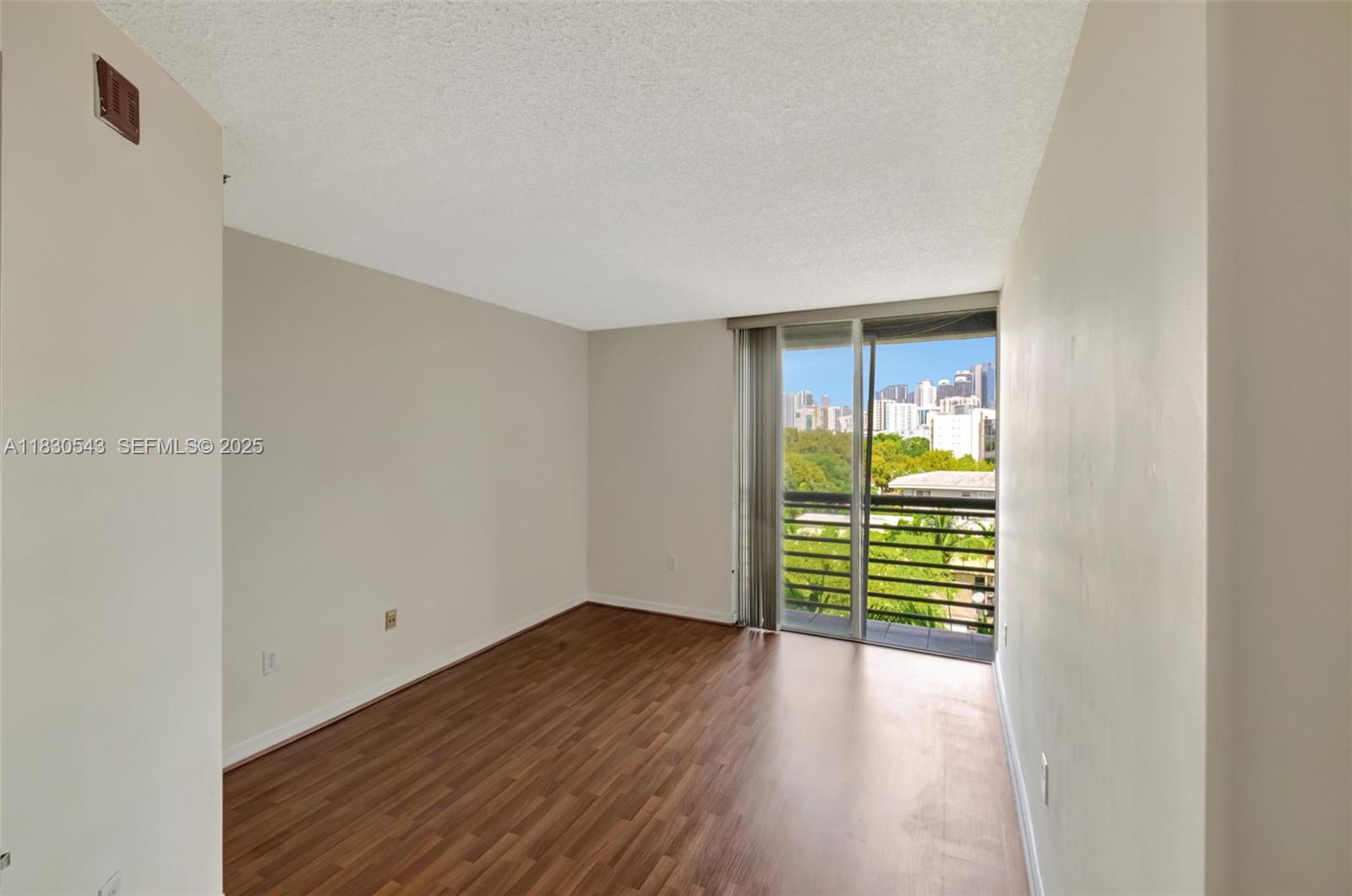 2400 Southwest 3rd Avenue, Unit 506 Miami, FL 33129 - Photo 15 of 28 a view of an empty room with wooden floor and a window