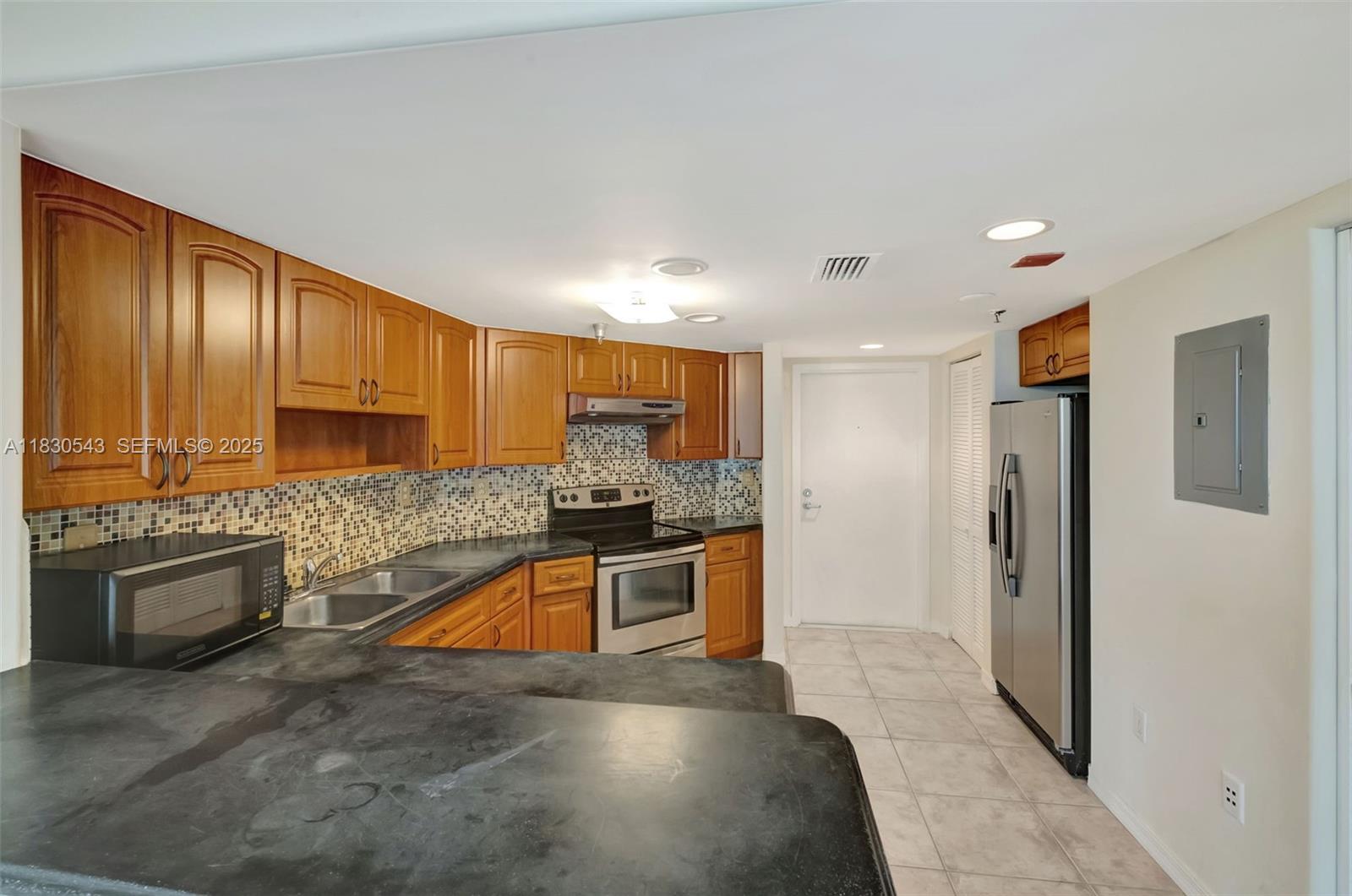 2400 Southwest 3rd Avenue, Unit 506 Miami, FL 33129 - Photo 8 of 28 a kitchen with stainless steel appliances granite countertop a refrigerator and a sink