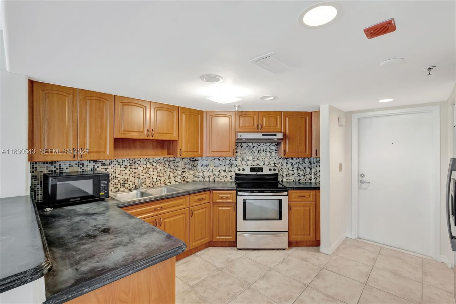 2400 Southwest 3rd Avenue, Unit 506 Miami, FL 33129 - Photo 9 of 28 a kitchen with stainless steel appliances granite countertop a stove a sink and a microwave