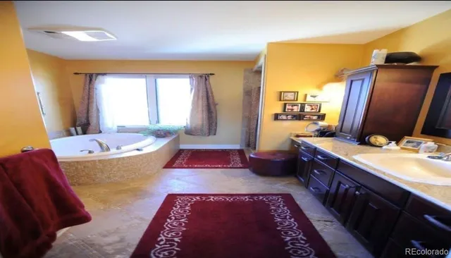 a large bedroom with a bed and wooden floor