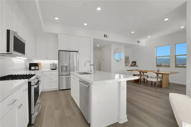 a kitchen with cabinets stainless steel appliances and wooden floor