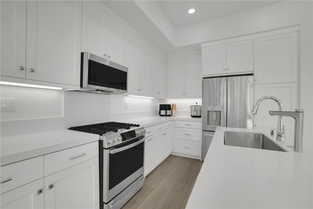 1958 Hollyleaf Terrace Montebello, CA 90640 - Photo 17 of 58 a kitchen with cabinets stainless steel appliances and wooden floor