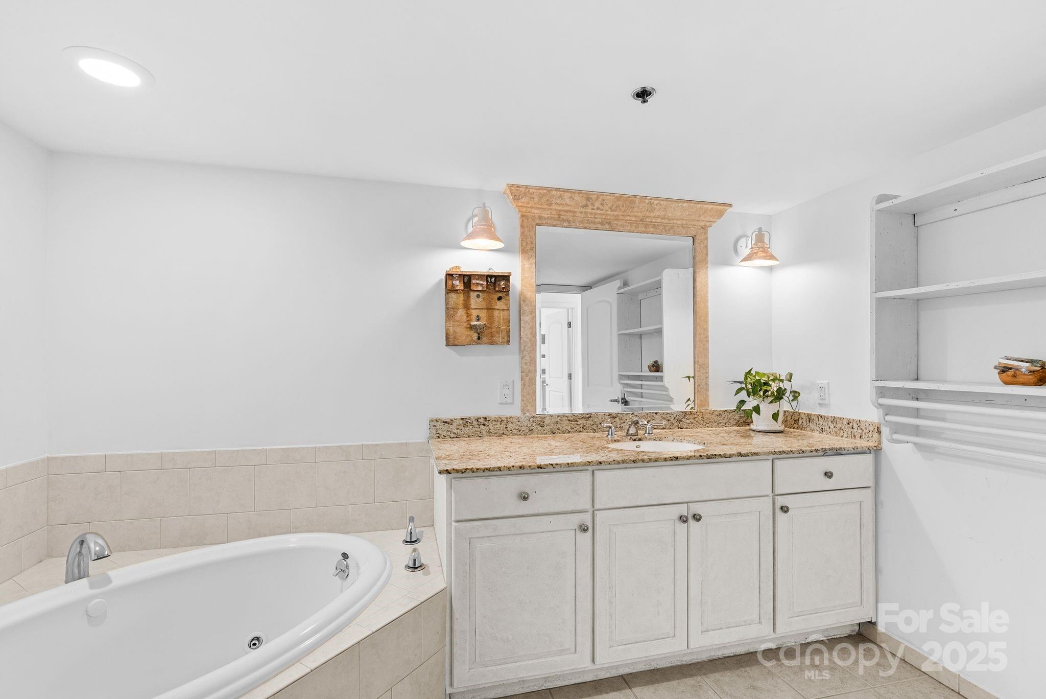 429 Bowling Park Road Asheville, NC 28803 - Photo 22 of 30 a spacious bathroom with a granite countertop sink and a bathtub