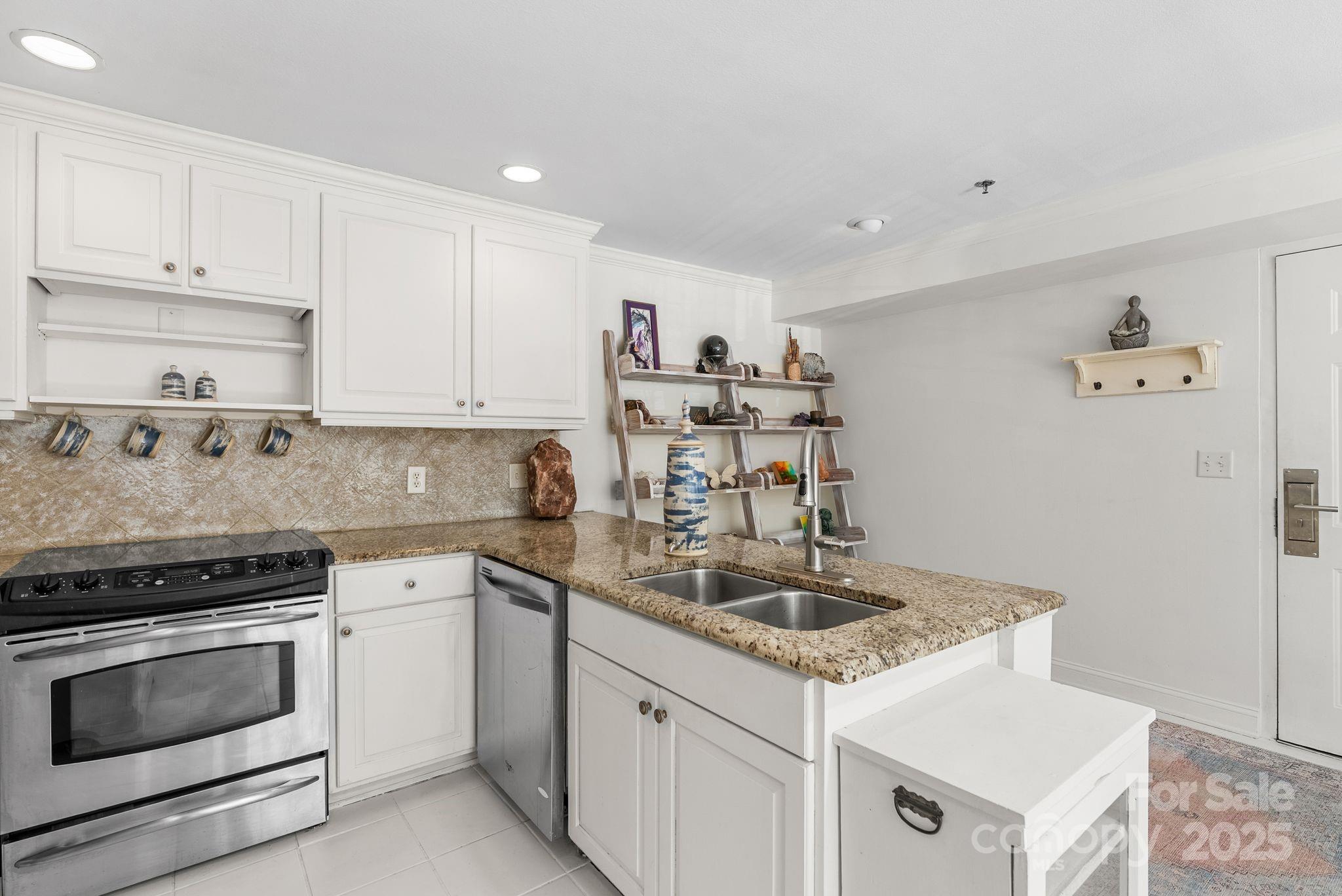 429 Bowling Park Road Asheville, NC 28803 - Photo 6 of 30 a kitchen with granite countertop a sink stove and cabinets
