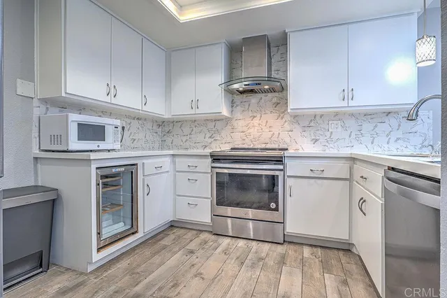 a kitchen with white cabinets and appliances