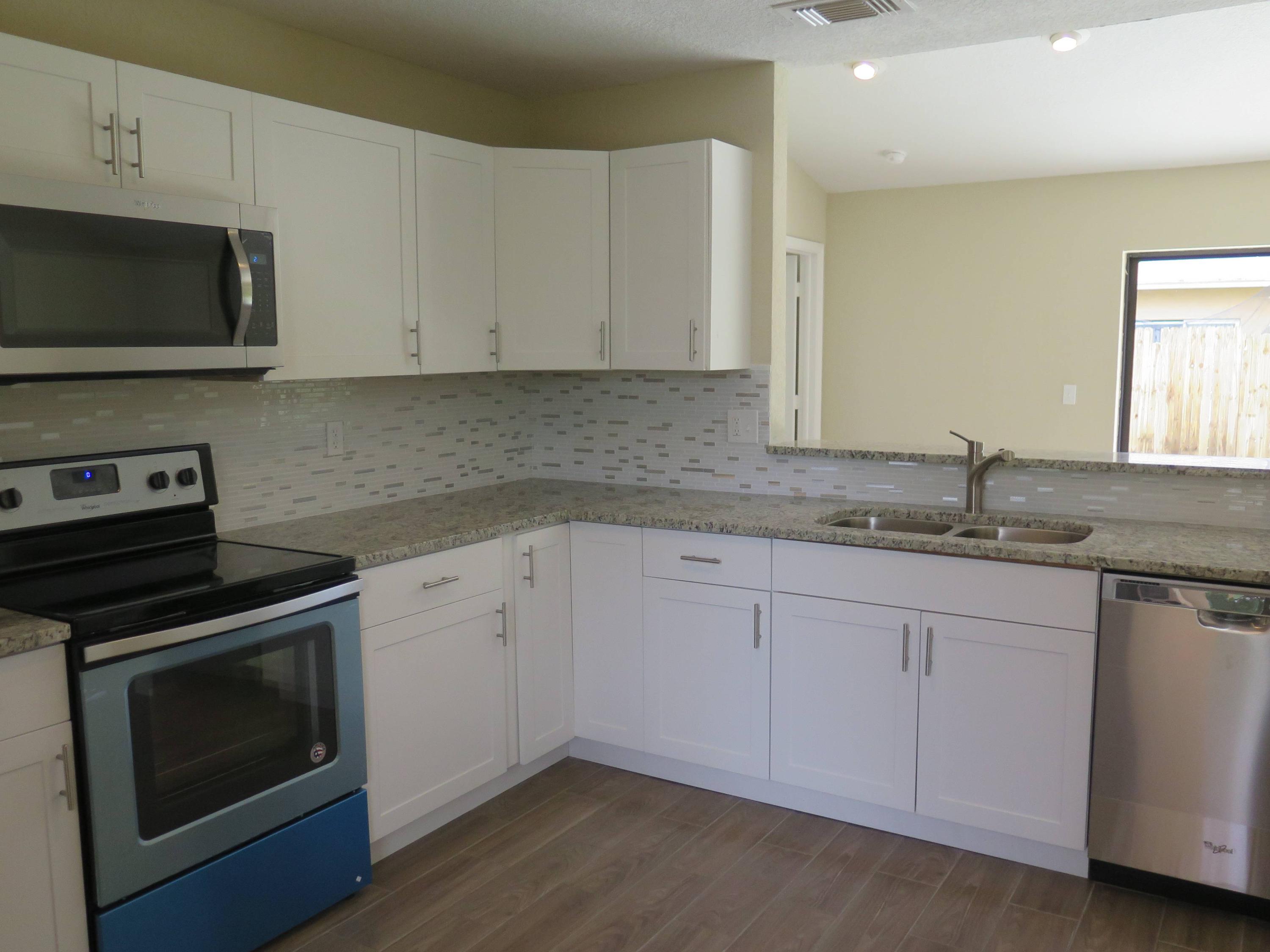 9744 Ohio Place Boca Raton, FL 33434 - Photo 3 of 20 a kitchen with granite countertop white cabinets stainless steel appliances and a sink