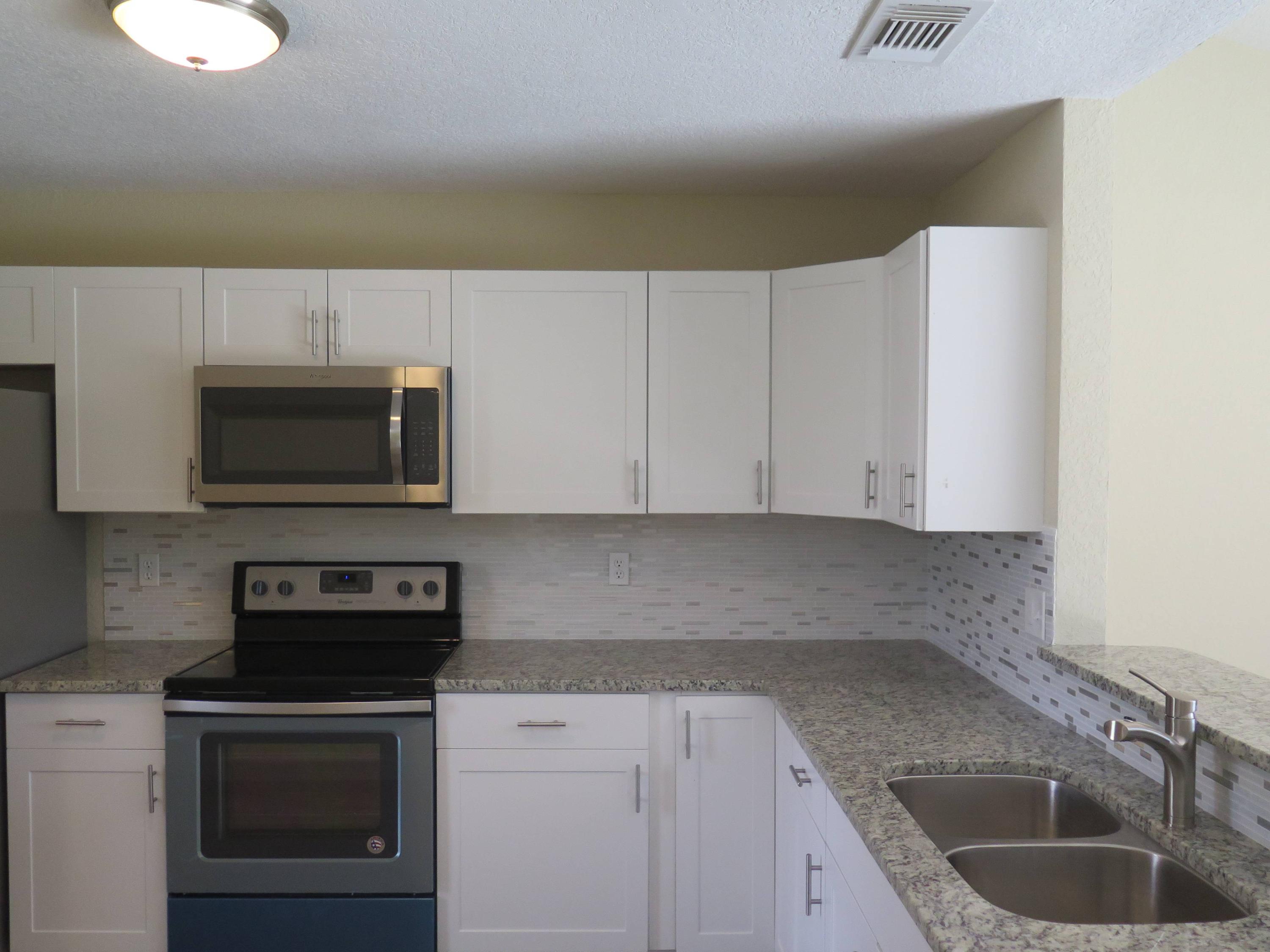 9744 Ohio Place Boca Raton, FL 33434 - Photo 4 of 20 a kitchen with granite countertop a sink a stove and microwave