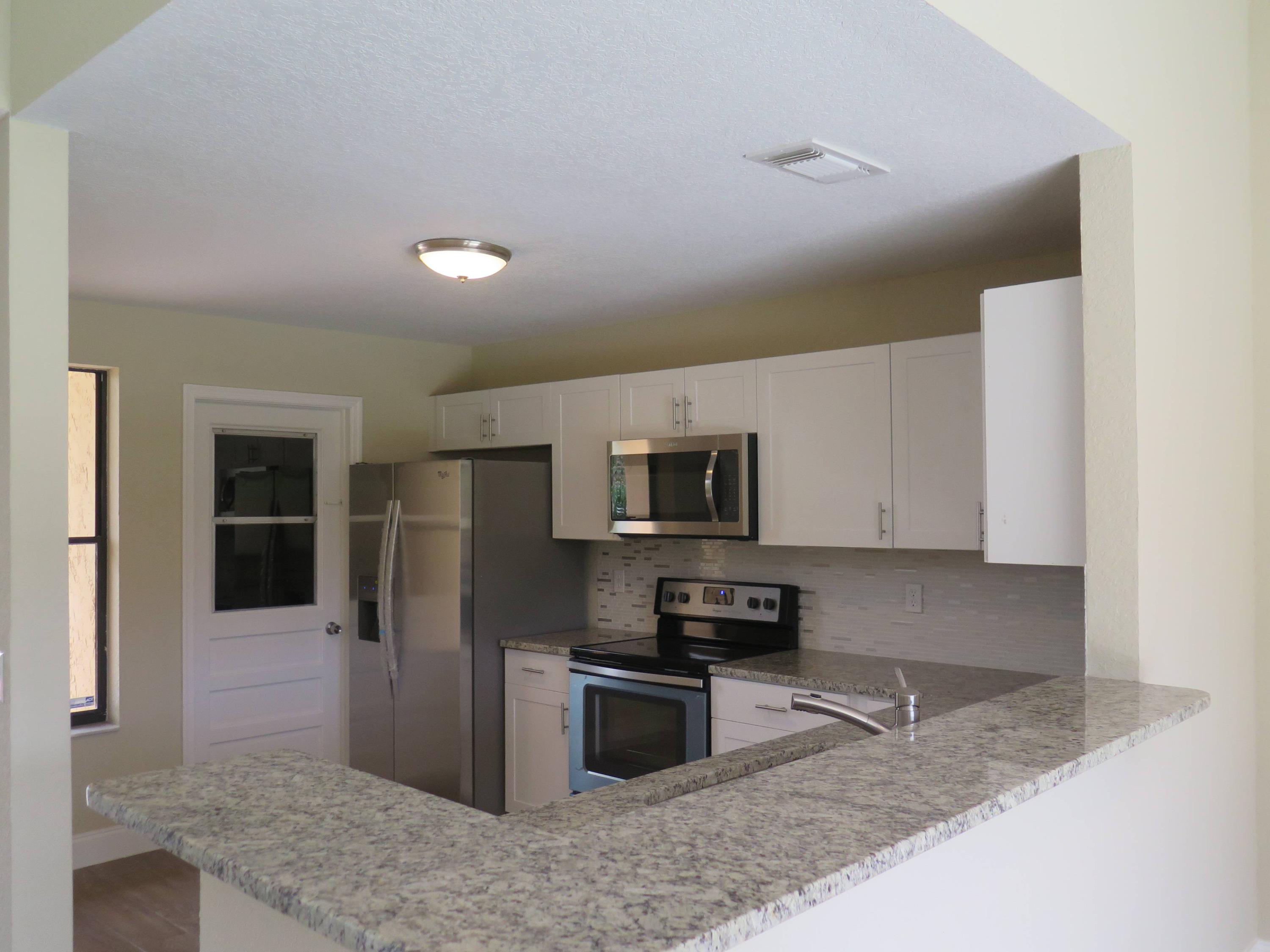 9744 Ohio Place Boca Raton, FL 33434 - Photo 5 of 20 a kitchen with stainless steel appliances granite countertop a refrigerator a stove and a sink