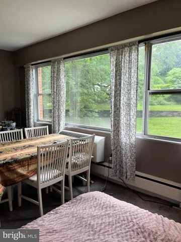 a bedroom with a bed a large window and a table