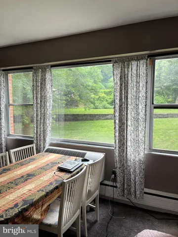 a view of a dining room with furniture and a large window