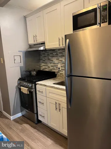 a kitchen with stainless steel appliances a refrigerator stove and microwave