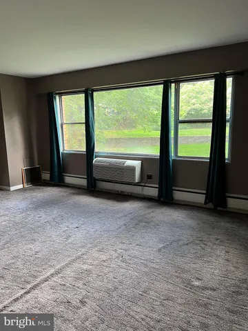 an empty room with large windows and view of balcony