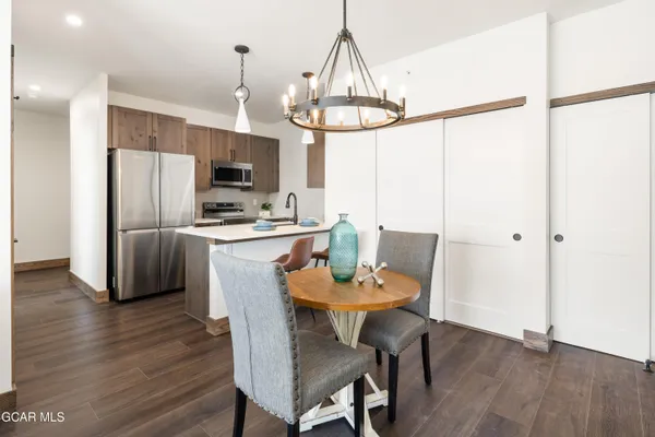 a dining room with furniture a chandelier and wooden floor