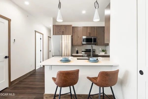 a kitchen with stainless steel appliances kitchen island granite countertop a dining table and chairs