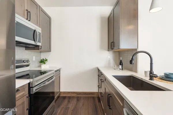 a kitchen with stainless steel appliances granite countertop a sink and stove top oven