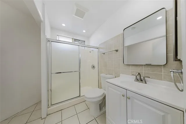 a bathroom with a shower sink mirror and toilet