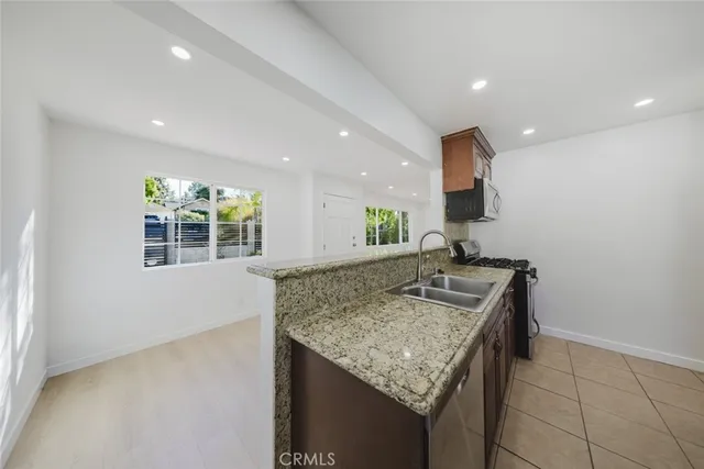 a kitchen with granite countertop kitchen island stainless steel appliances a sink and a counter top