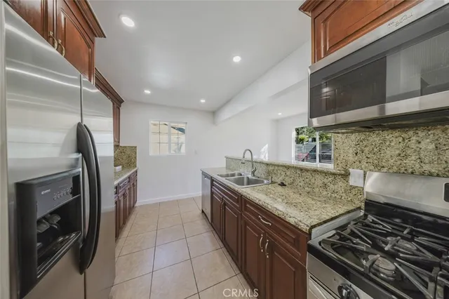 a kitchen with granite countertop a sink and a stove